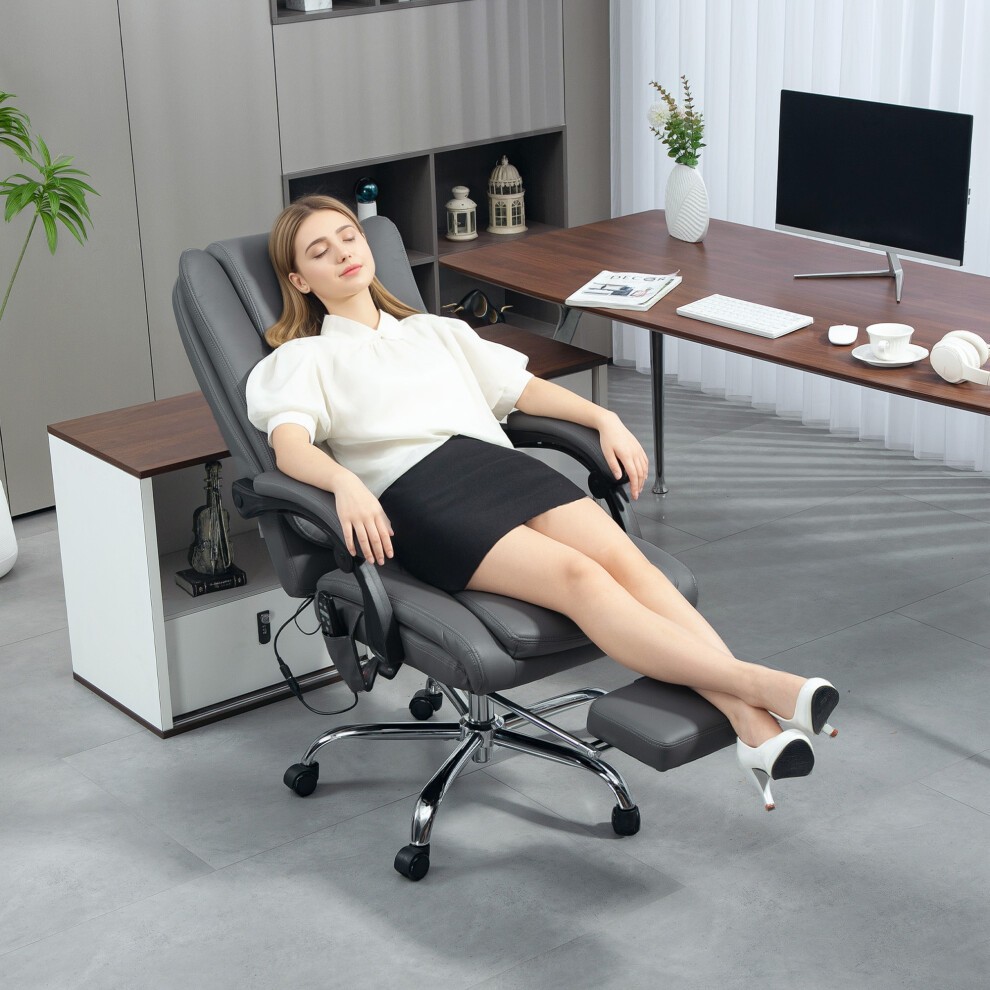 Light grey PU leather executive office chair with a heated massage feature, reclining backrest, and adjustable footrest, set in a modern office environment.