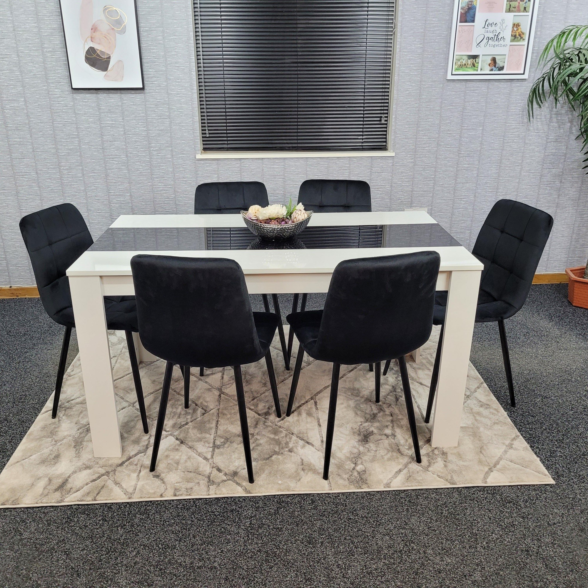 Wooden dining table set with a white finish and black velvet tufted chairs, featuring a rectangular glass top, six chairs, and a decorative bowl centerpiece.
