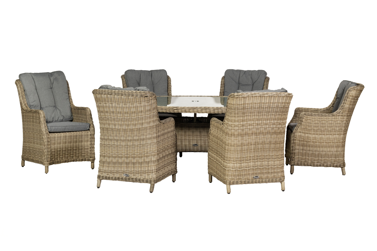 Cream-colored highback dining set with six woven rattan chairs featuring grey cushions, surrounding a rectangular glass-top table.