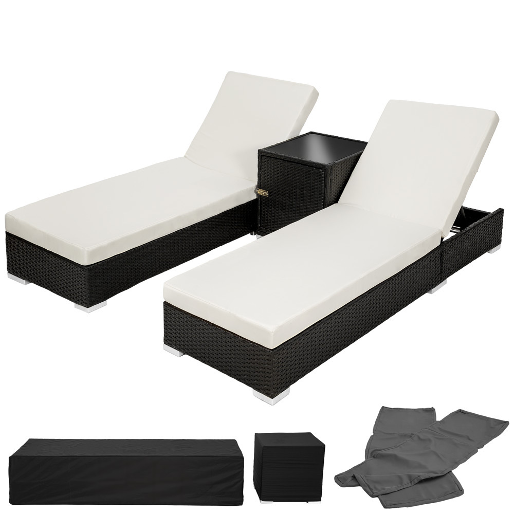Two black rattan sunloungers with cream cushions and a matching side table, accompanied by a protective cover and additional grey covers.