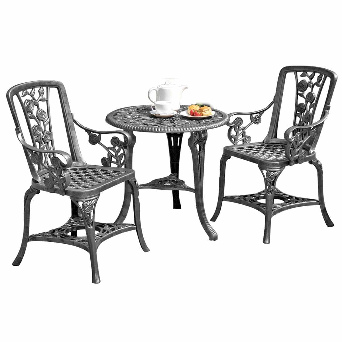 Three-piece bistro set in pewter grey featuring a round table with intricate floral designs and two matching chairs with decorative backs, ideal for outdoor settings.