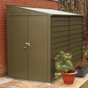 Green metal bike shed with a sloped roof, double doors, and ventilation slots, featuring a secure lock and positioned beside a potted plant on a patio.
