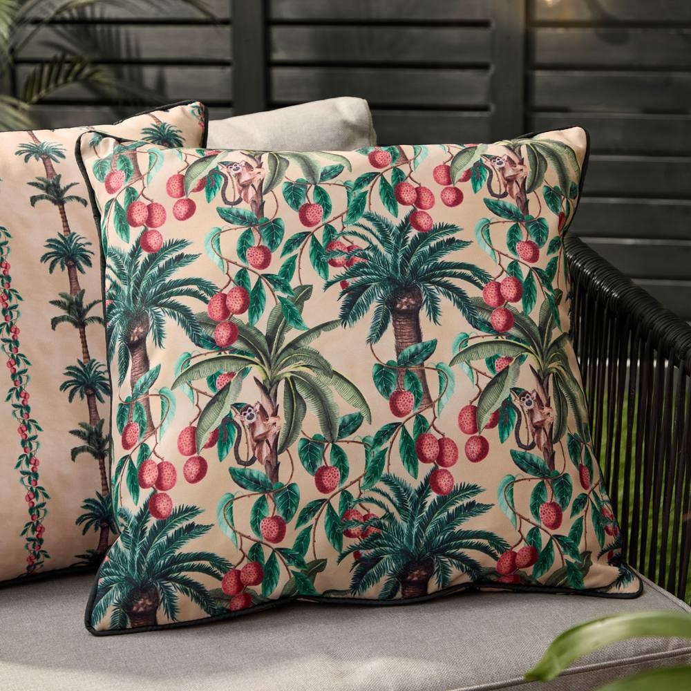 Natural-colored cushion featuring a vibrant tropical print with palm trees and playful monkeys, accented by red fruit, bordered with a black trim.