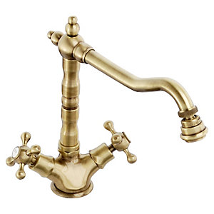 Antique brass kitchen mixer tap with a curved spout, decorative cross handles, and a traditional design, featuring a polished finish and elegant detailing.