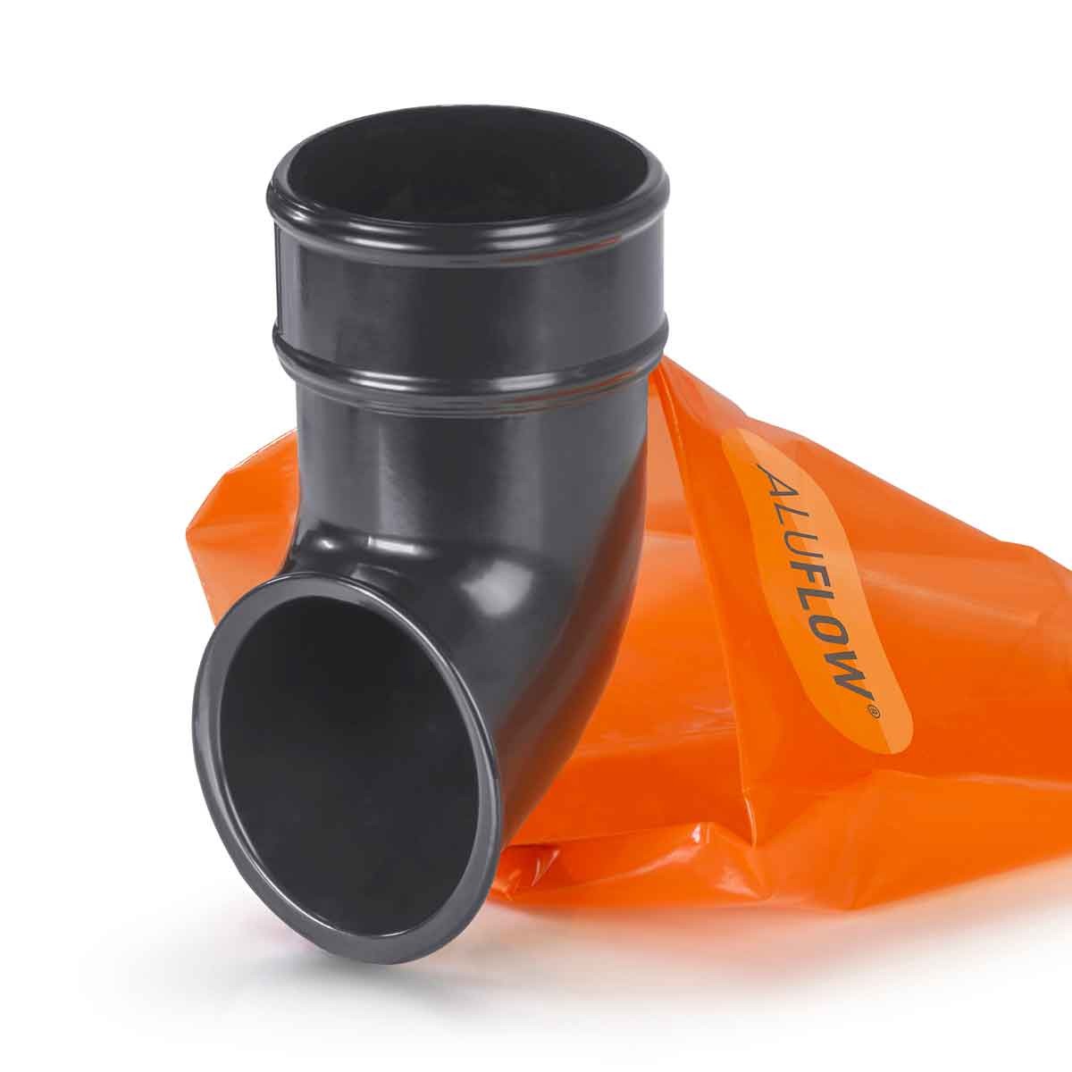 Grey Aluflow downpipe shoe made of durable material, featuring a curved design and a smooth finish, with an orange bag labeled "ALUFLOW" in the background.