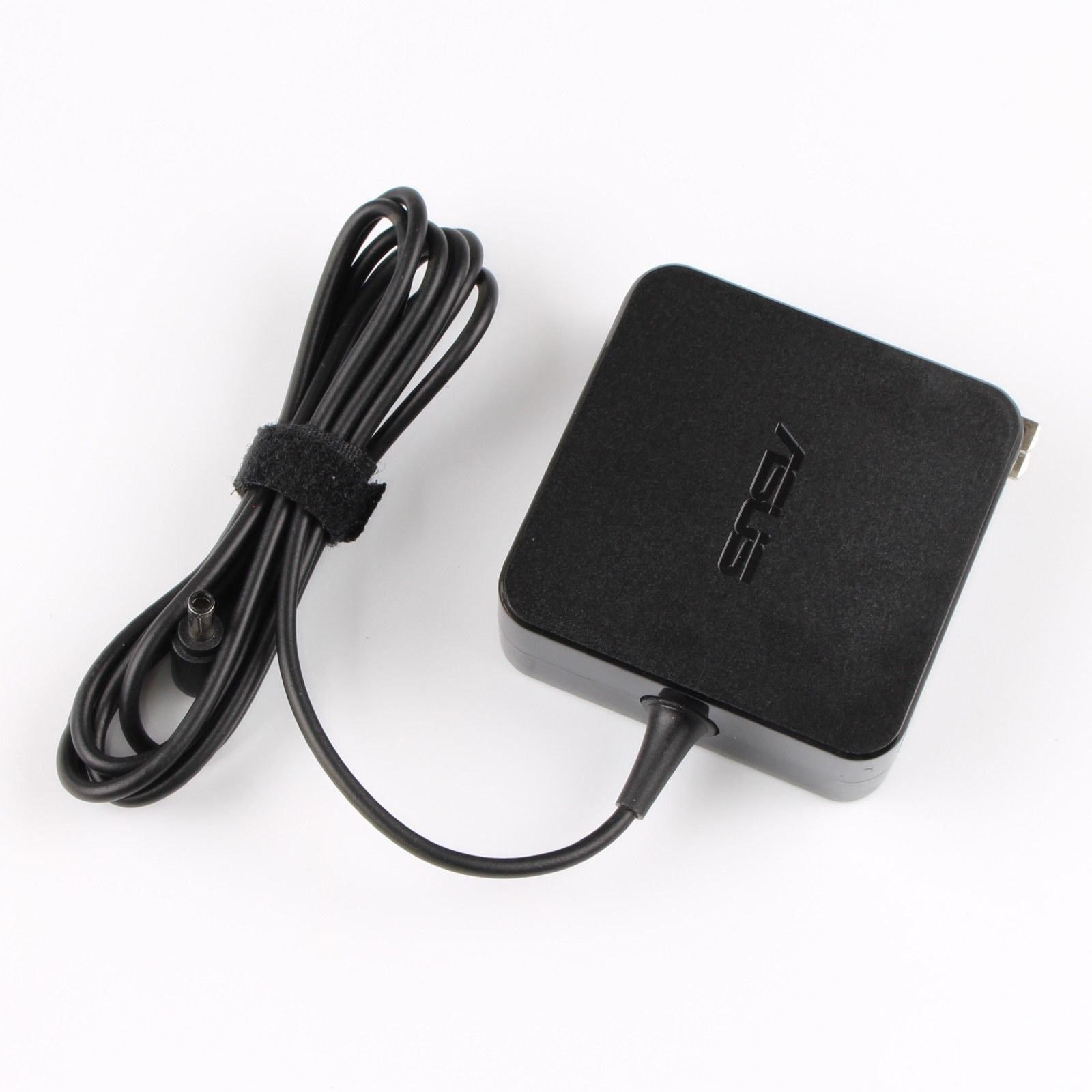 Black ASUS 65W power adapter with a square design, featuring a detachable cable and a velcro strap for organization, marked with the ASUS logo on the top surface.