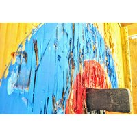 Axe embedded in a colorful wooden target with blue and red paint, part of an axe throwing experience for two.