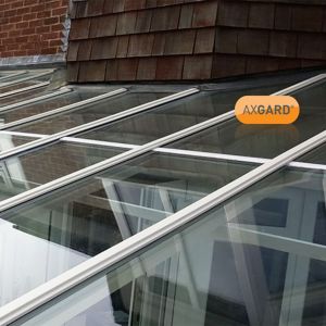 Clear 2mm UV protected polycarbonate roofing sheet with a transparent finish, measuring 1000 x 2000mm, showcased on a sloped roof with wooden shingles.