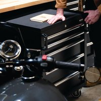 Black modular storage unit with multiple drawers, silver handles, and a hardwood worktop, part of a 16-piece set.