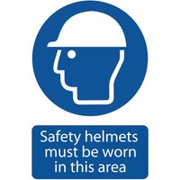 Blue circular sign with white helmeted head icon and text "Safety helmets must be worn in this area" below.