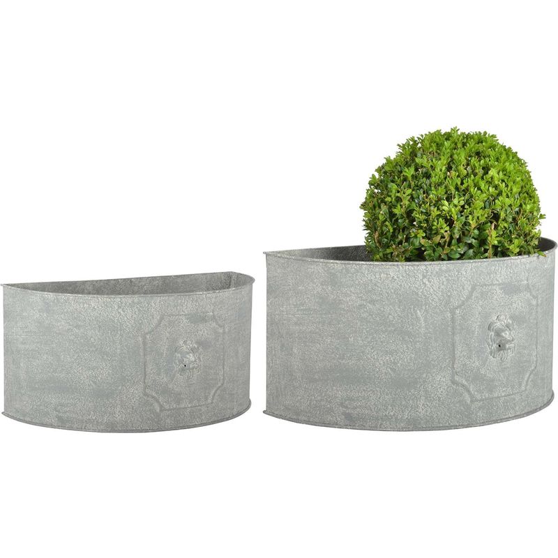 Set of 2 aged metal semicircle planters featuring a lion head design, finished in a weathered gray, with one planter holding a lush green topiary.