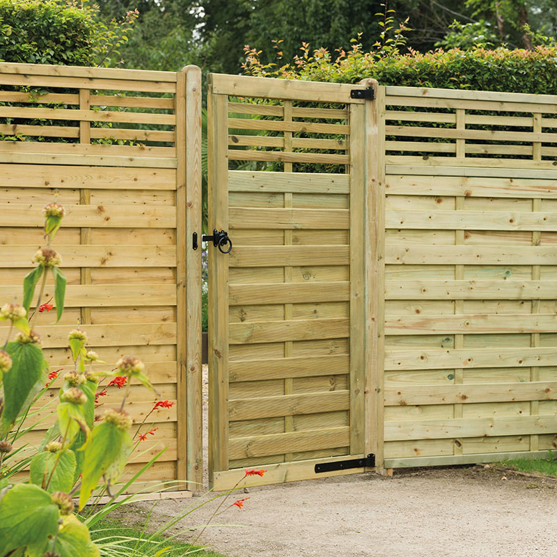 Wooden garden gate in natural finish, measuring 1.8 x 0.9m, featuring horizontal slats, a latch mechanism, and surrounded by greenery and vibrant flowers.