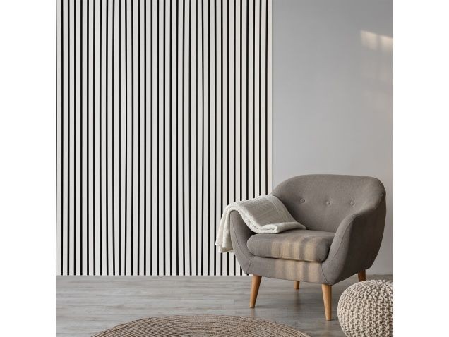 Acoustic wooden wall panel in white oak, measuring 2.4m x 0.6m, features vertical stripes and complements a modern gray chair with a cozy throw.