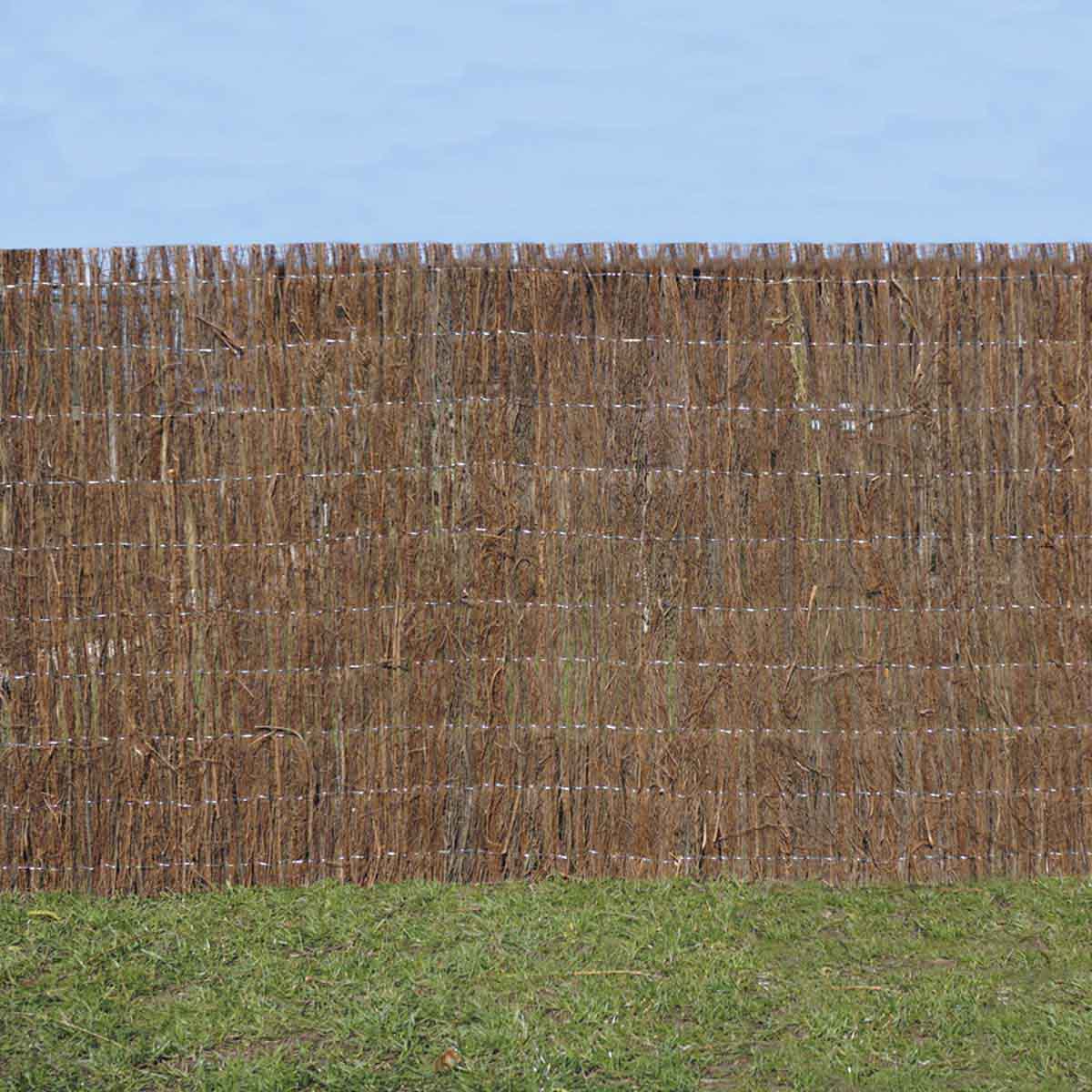 Brown brushwood thatch screen roll by Garden Gear, made of natural materials, features a textured, woven design, ideal for garden privacy or decoration, set against a grassy background.