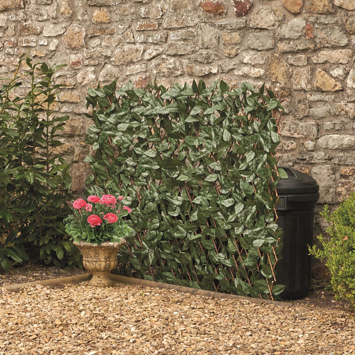 Green ivy leaf folding hedge trellis, measuring 1x2m, made of durable material, featuring a natural leafy design, positioned against a stone wall with a flower pot nearby.