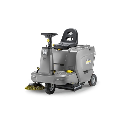 Karcher KM 85/50 R BP vacuum cleaner in grey, featuring a comfortable black seat, steering wheel, and a front-mounted yellow brush for efficient sweeping and cleaning.