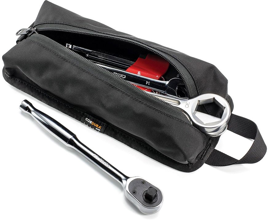 Black Codura pouch tool bag with a zippered closure, featuring a durable fabric, a handle, and tools like a ratchet and pens visible inside.