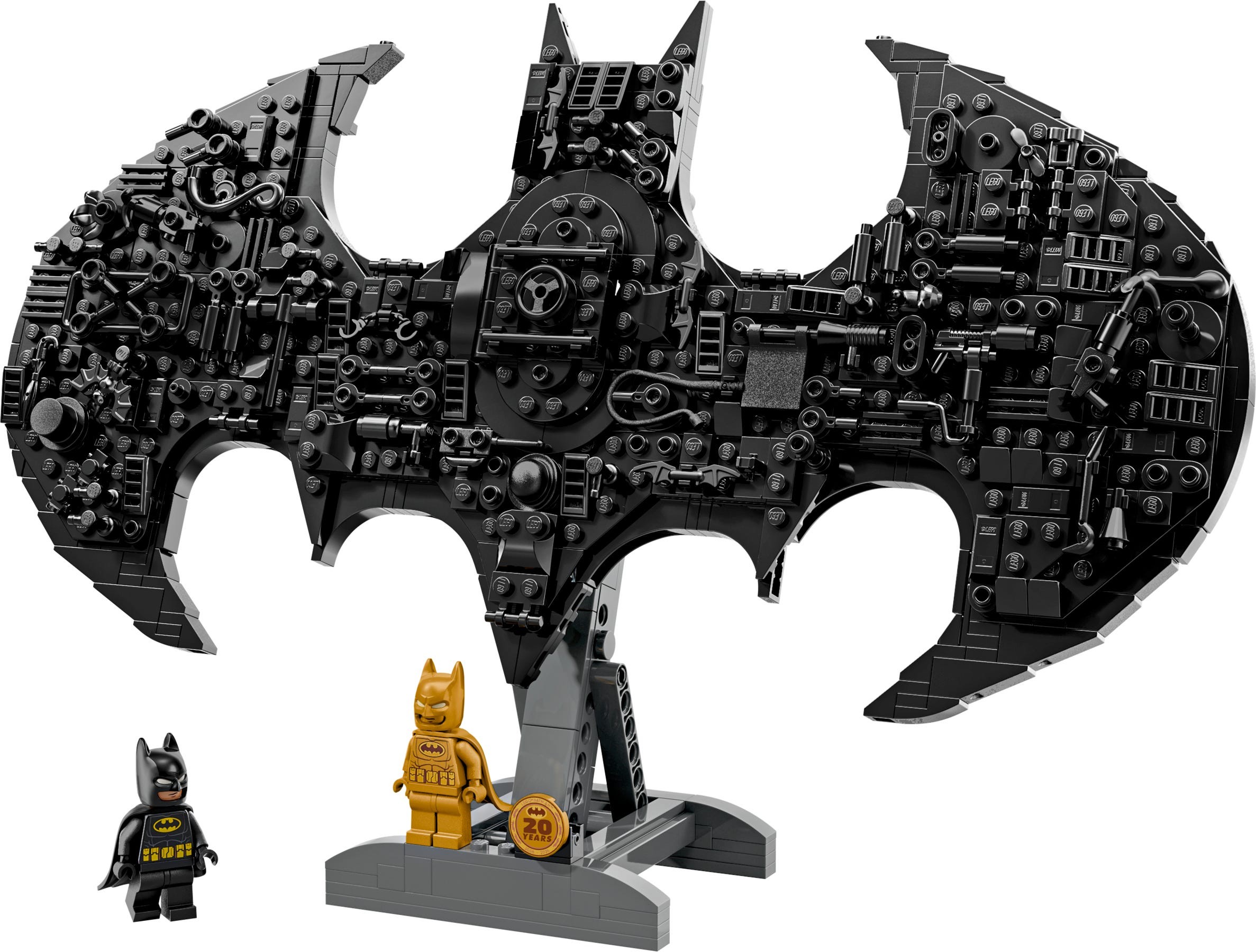 Black Batman logo constructed from interlocking pieces, featuring intricate details, with two Batman mini-figures in front, one in classic suit and one in gold.