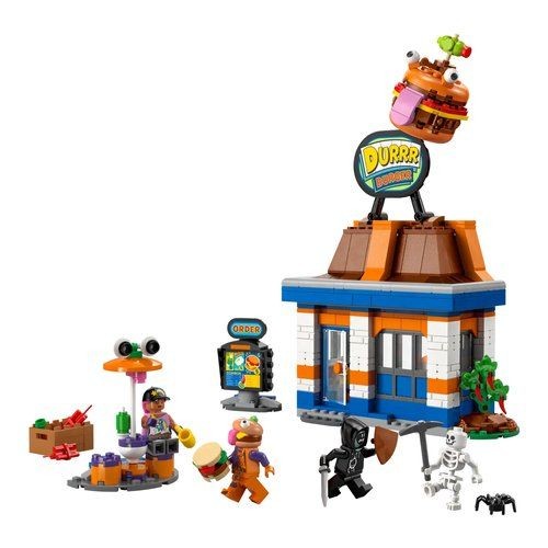Colorful LEGO set featuring a burger restaurant with a large burger sign, orange and blue building, outdoor seating, and minifigures including a chef and a skeleton.