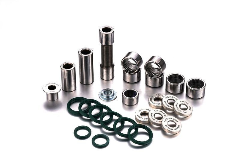 Suspension linkage repair kit featuring various metal bushings, bearings, and green rubber seals, all labeled with "Factory Links" in white.