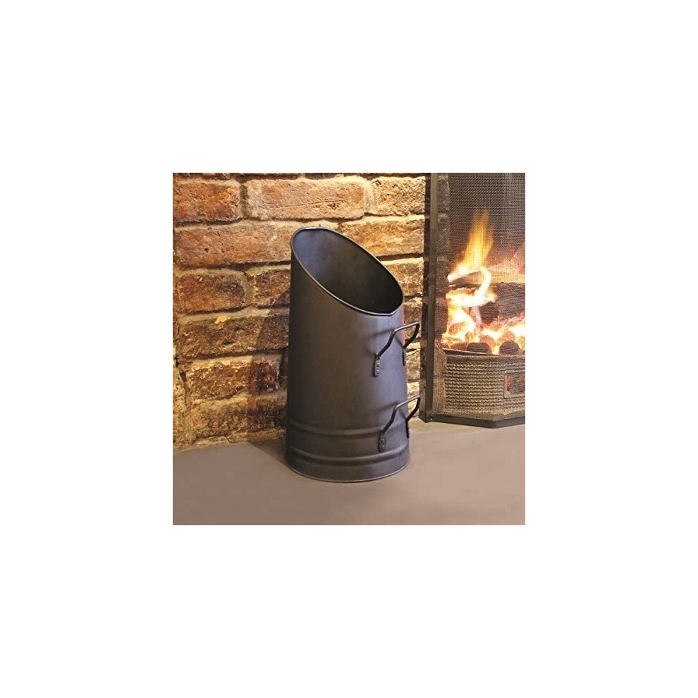 Tall black coal scuttle with a curved design, featuring two handles, made of metal, positioned beside a brick fireplace with a fire burning.