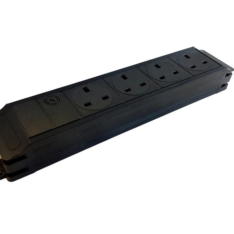 Black power strip with four UK sockets, designed for under-desk use, featuring a sleek plastic body and a power switch on one end.