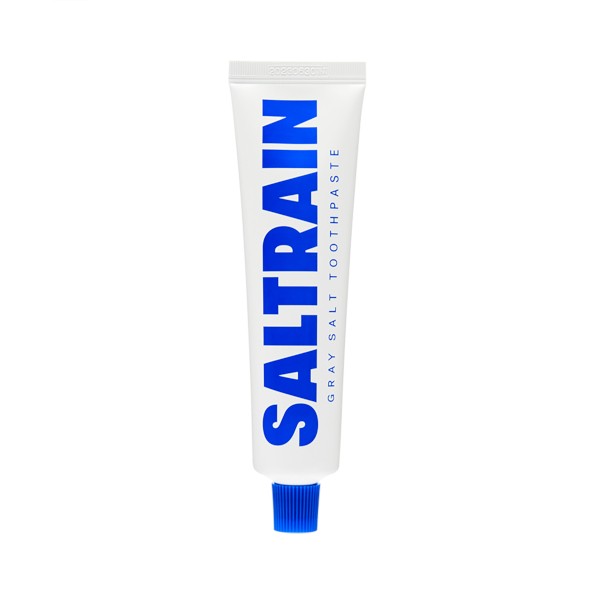 White toothpaste tube with a blue label reading "SALTRAIN" and "GRAY SALT TOOTHPASTE," featuring a blue cap and 100g capacity.