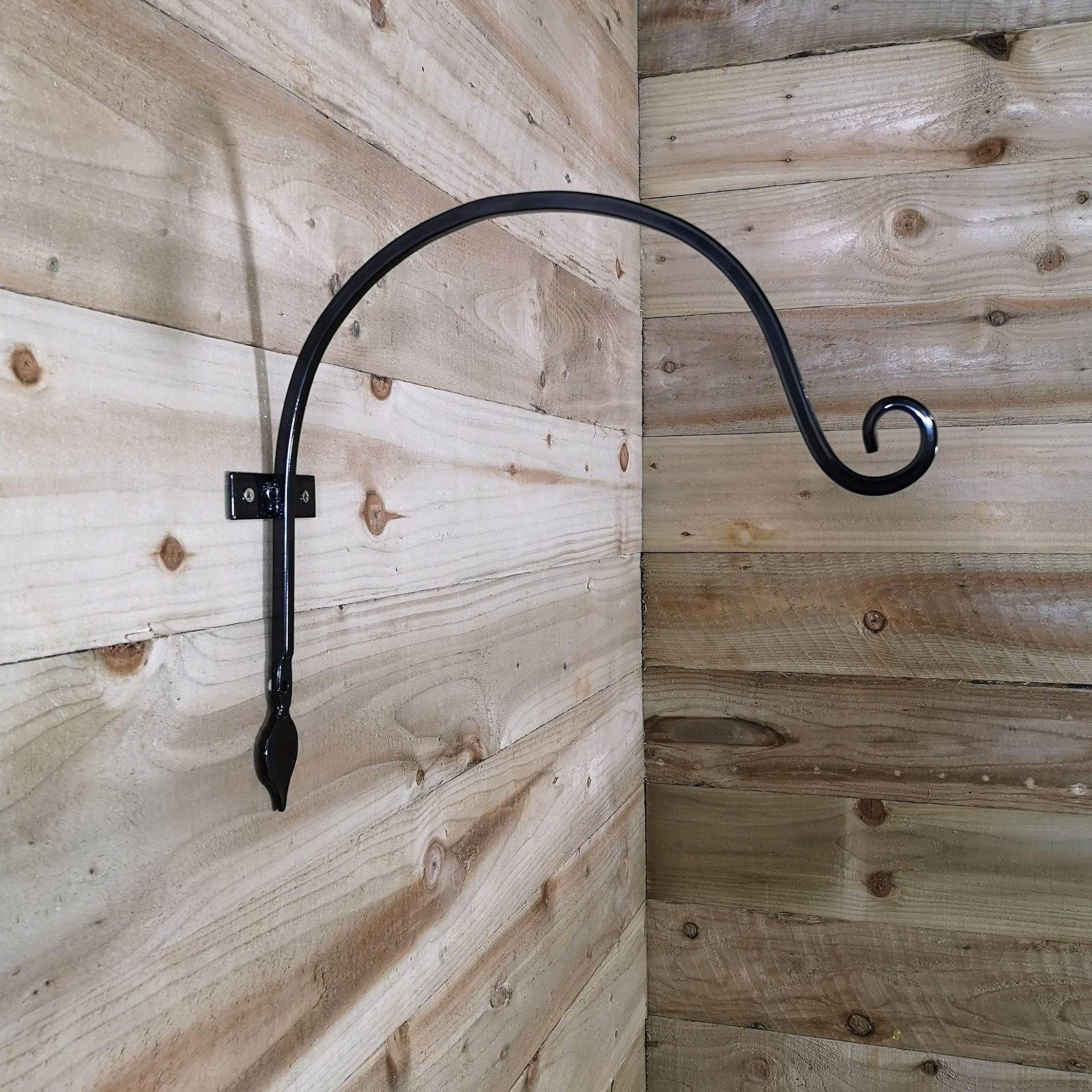 Heavy-duty handcrafted black metal wall bracket hook, 38cm long, featuring a curved design with a decorative scroll end, mounted on a wooden wall.