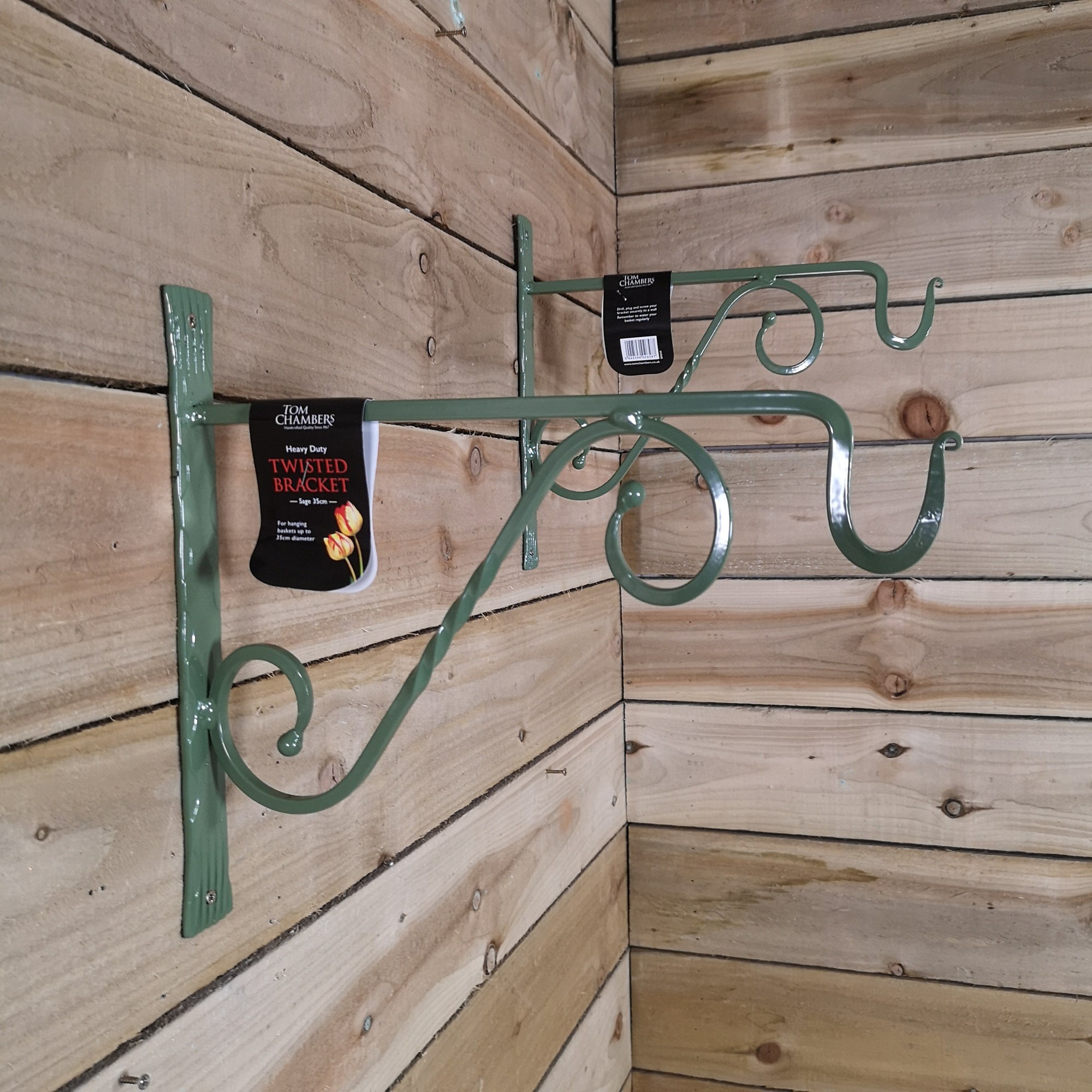 Pack of 2 sage green, handcrafted metal wall bracket hooks with a twisted design, measuring 35cm, suitable for hanging baskets or bird feeders.