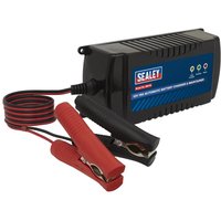 Black Sealey battery charger with blue label, red and black clamps, ribbed design, and coiled cables.