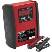 Red and black Sealey Schumacher battery charger with digital display and attached red and black clamps.
