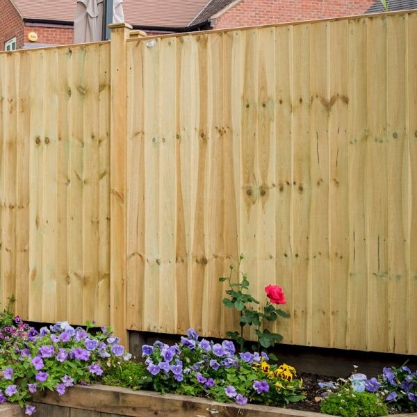 Green featheredge fence panel made of wood, standing 0.9m tall, with a smooth finish, surrounded by colorful flowers in a garden setting.