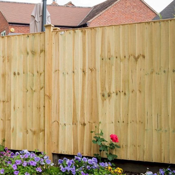 Wooden featheredge panel fence in natural wood color, measuring 1.65m, featuring vertical slats and a smooth finish, with colorful flowers in the foreground.