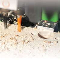 "Trend dowel drill, 6mm diameter, black with spiral flutes, drilling into wood with shavings around the hole"