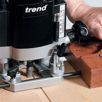 Black and silver Trend router with two flute cutter, 12mm diameter, 50mm cut length, cutting into wood.