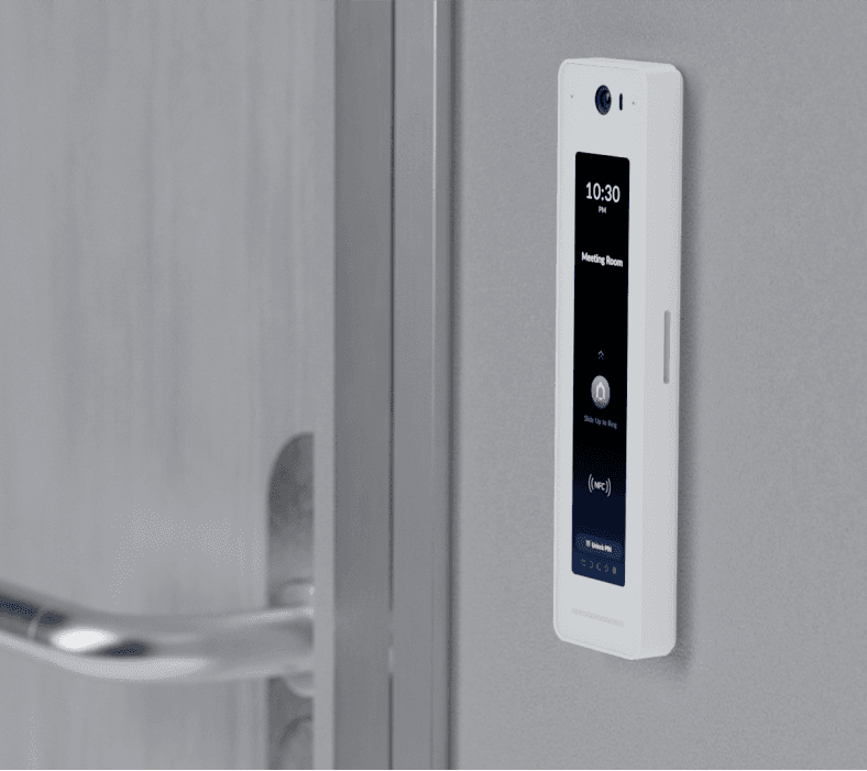 White UA-G2 UniFi Access Reader G2 Professional mounted on a wall beside a door, featuring a touchscreen display showing time and room status.