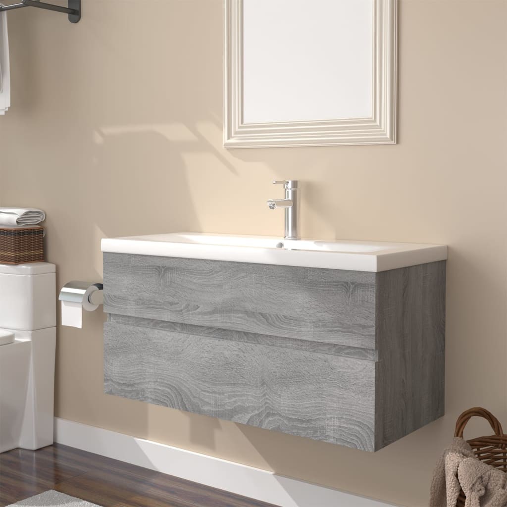 Grey Sonoma engineered wood sink cabinet with a built-in white basin, featuring two pull-out drawers and a sleek, modern design, mounted on a wall.