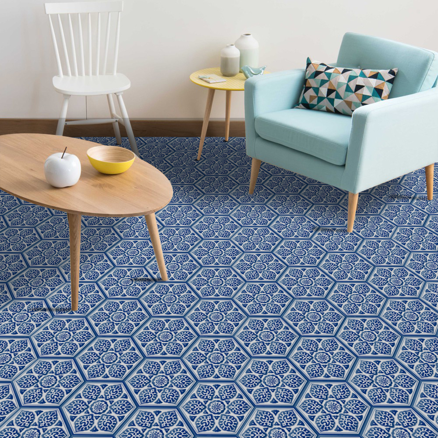 Porcelain blue hexagon floor tile stickers featuring intricate patterns, set in a stylish living room with a light blue chair, wooden table, and decorative items.