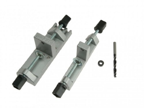 Universal dowel fixer in silver metal with adjustable clamps, includes a drill bit and a small black rubber ring, designed for precise alignment in woodworking projects.