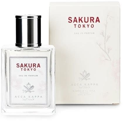 Clear glass bottle with a silver cap, labeled "Sakura Tokyo" in elegant red font, alongside a cream-colored box featuring subtle floral designs.
