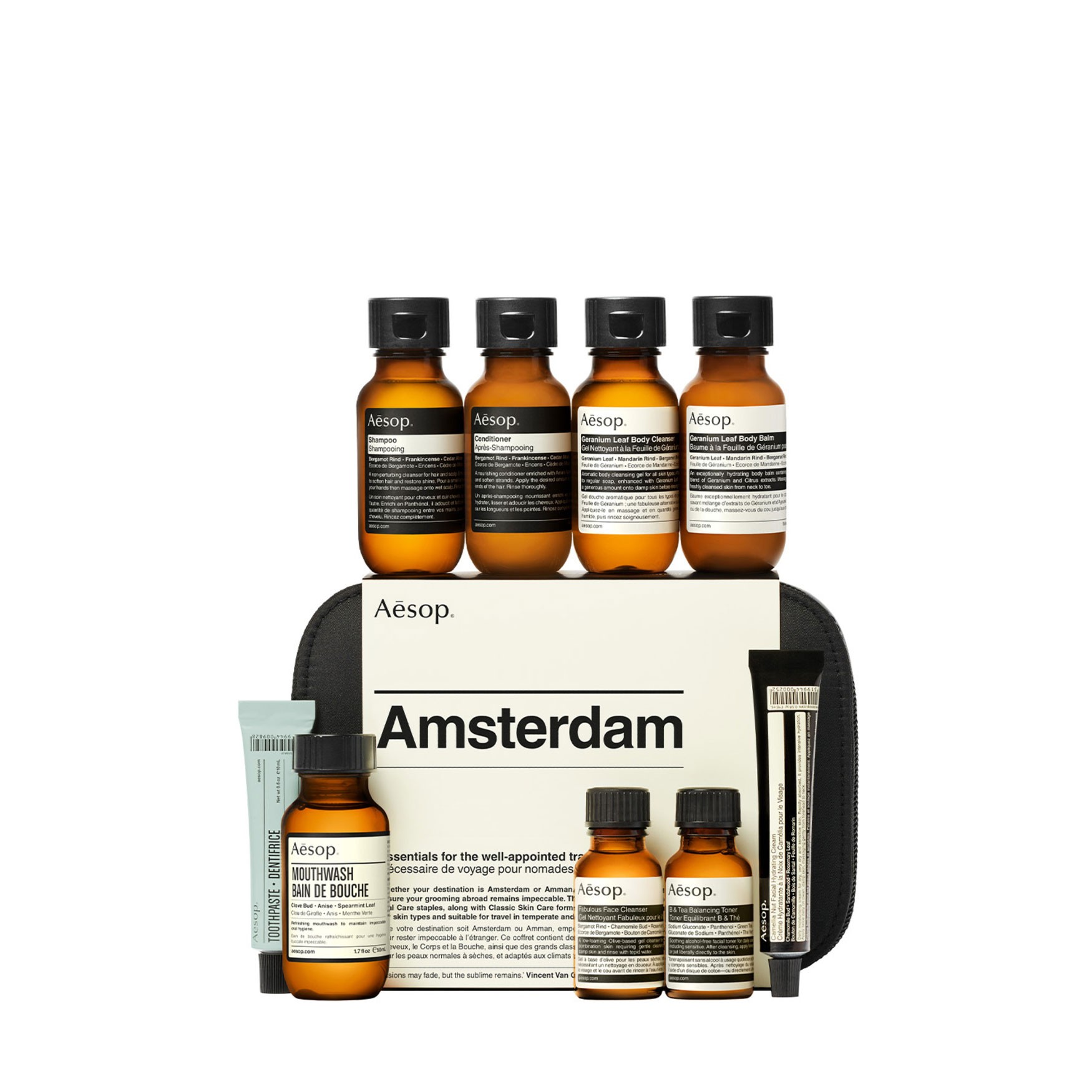 Aesop Amsterdam City Kit featuring amber glass bottles of skincare products, a black zippered pouch, and a cream-colored card with "Amsterdam" printed in bold.