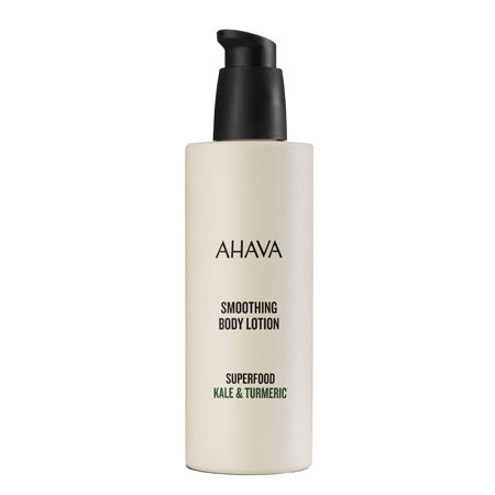 Cream-colored bottle with a black pump top, labeled "AHAVA Smoothing Body Lotion" featuring "Superfood Kale & Turmeric" in green text.