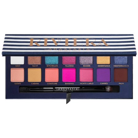 Riviera Eyeshadow Palette featuring 14 vibrant shades in a mix of matte and shimmer finishes, housed in a striped navy and gold case with a dual-ended brush.