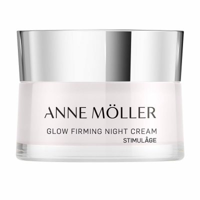 A sleek, clear glass jar with a silver lid, containing Anne Möller StimulâGE Glow Firming Night Cream, labeled prominently in black text.