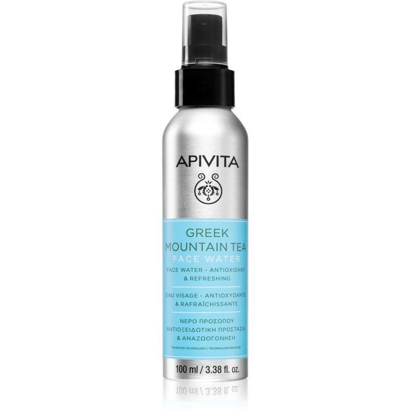 Silver spray bottle with a blue label, featuring "Greek Mountain Tea Face Water" in bold letters, and APIVITA logo on top, 100ml size, designed for hydration and antioxidant benefits.