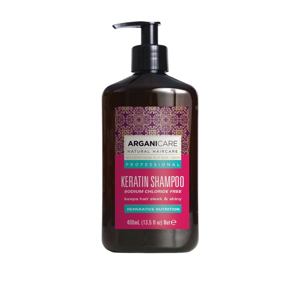 Brown plastic bottle with a black pump, labeled "ARGANICARE KERATIN SHAMPOO," featuring a pink and gold design, 400ml, sodium chloride free, promoting sleek and shiny hair.