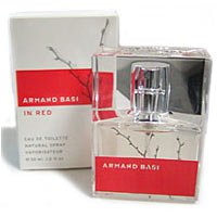 Clear glass bottle with a silver cap, featuring a minimalist design and a red label, alongside a matching red and white box, both labeled "Armand Basi in Red."