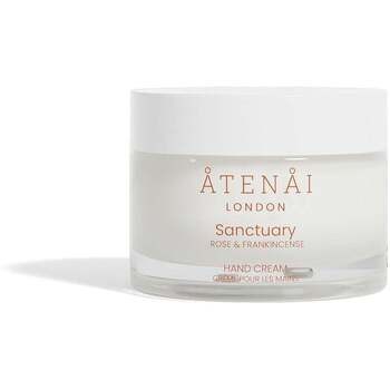 Three 50ml jars of Atenai London hand cream in white containers, featuring a minimalist design with gold lettering, showcasing scents of rose and frankincense.