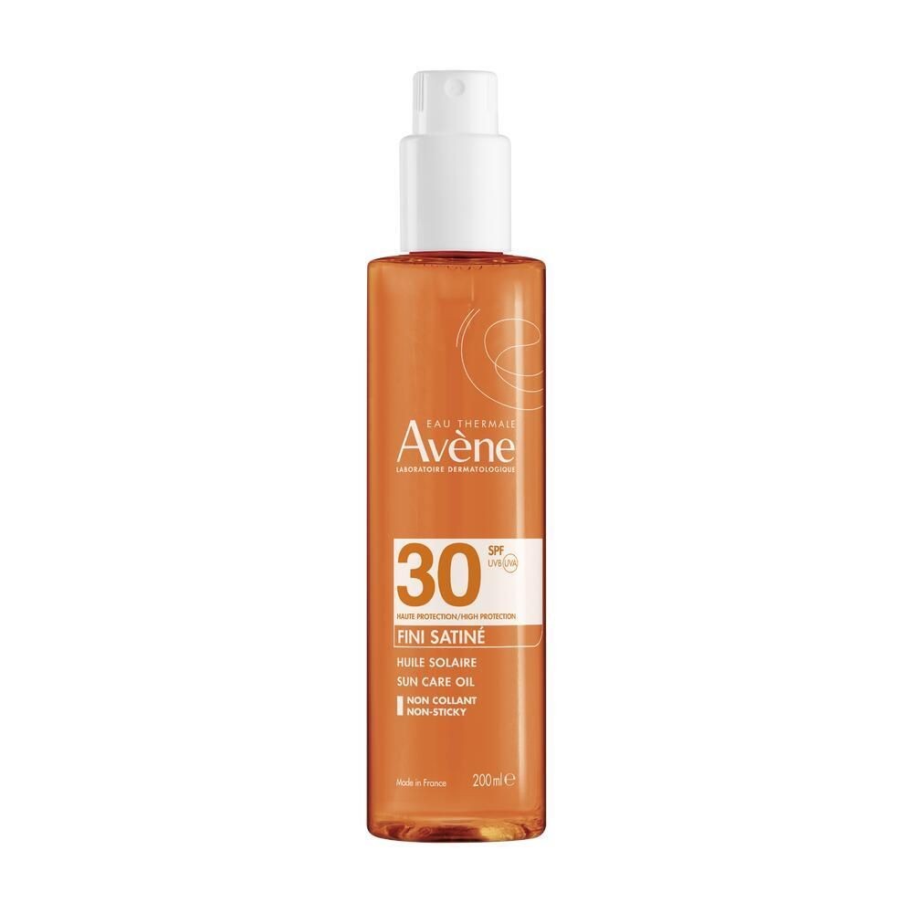 Transparent bottle of Avène Sun Care Tanning Oil Spray SPF 30, featuring a white spray nozzle, orange liquid, and a label with white text on a light background.
