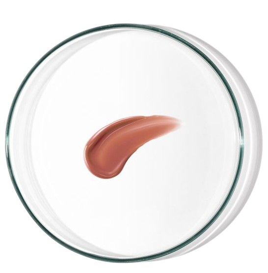 A circular glass container holds a creamy, orange-tinted lip and cheek product, showcasing a smooth, glossy swatch on a white background.